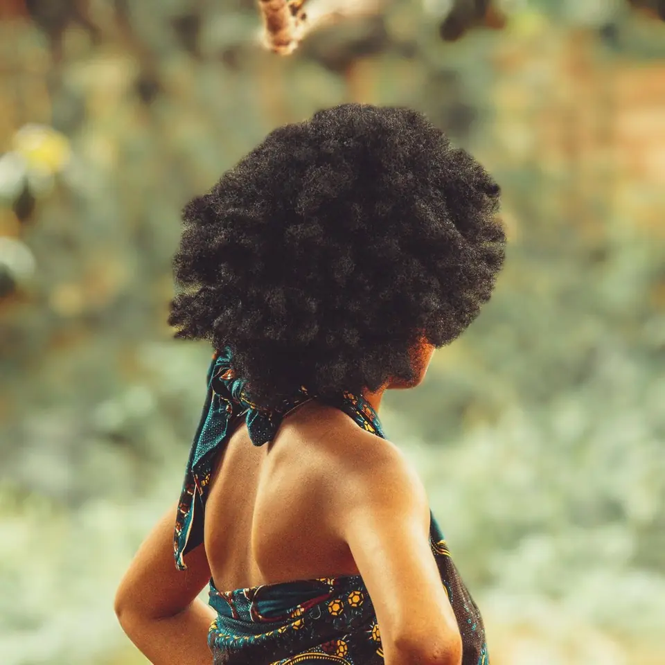Full natural coils seen from behind, outdoors in soft light