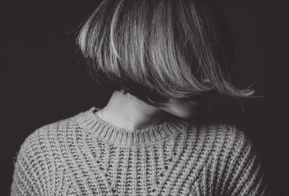 Black-and-white rear view of a sharp bob above a knitted collar